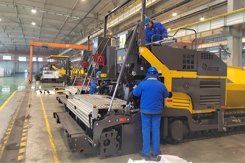 1、工人們抓緊時間總裝即將出口的瀝青混凝土攤鋪機.jpg